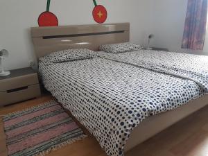 a bedroom with a bed with a black and white comforter at Apartment Šinc in Kobarid