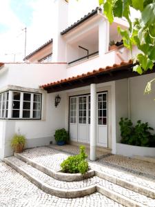 ein weißes Haus mit einer Treppe davor in der Unterkunft Casa dos Pocinhos Férias tranquilas no campo in Torres Novas