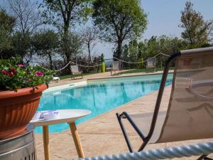 una piscina con una silla, una mesa y una planta en Seregnér Agricamping - Adults Only 18 - solo piazzole libere per camper, tende e roulotte, en Monzambano