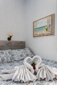 twee handdoeken in de vorm van een hart op een bed bij Villa Christina in Spetses