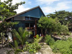 una casa en medio de un jardín en Castaway Surf Retreat 1 en Sekongkang