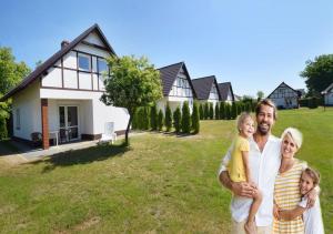 a family standing in front of a house at Morska Kraina in Białogóra
