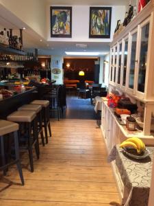 a restaurant with chairs and a bar with bananas on the counter at B&B Geste d' Alice in Middelkerke