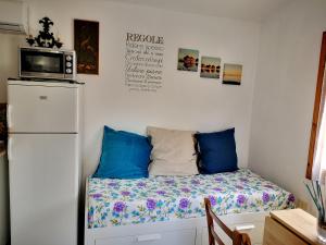 a room with a bed with a microwave and a refrigerator at Il Capperino in Capoliveri