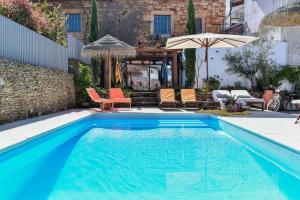 uma piscina azul com cadeiras e um guarda-sol em Feel Discovery Douro Janja em Armamar