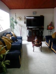 a living room with two couches and a tv at Hotel El Triangulo in Pitalito