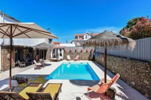 una villa con piscina con sedie e ombrelloni di Feel Discovery Douro Janja ad Armamar