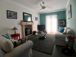 ein Wohnzimmer mit 2 Sofas und einem Kamin in der Unterkunft Secret Cottage in Dassia