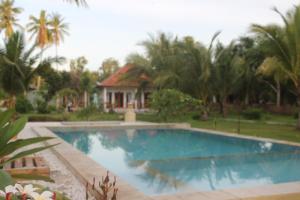 a swimming pool in front of a house at Wani Bali Bungalow in Nusa Penida