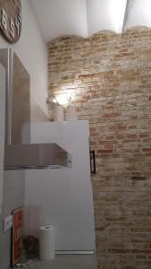 a white refrigerator in a room with a brick wall at Luxury Apartment In Triana Close To The River in Seville