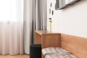 una habitación con un banco y un jarrón con una flor en Skaline Luxury rooms Split, en Split