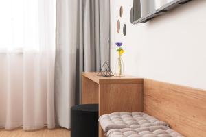 a room with a bench and a vase with a flower at Skaline Luxury rooms Split in Split