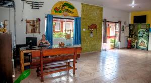 une femme assise au comptoir dans une pièce dans l'établissement Pousada Sucuri, à Bonito