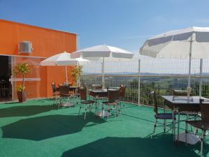 eine Terrasse mit Tischen, Stühlen und Sonnenschirmen in der Unterkunft Hotel ITR-SPA in Itupeva