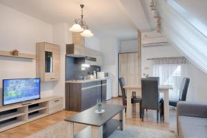 a living room with a kitchen and a dining room at Fortuna 7 Apartments in Hévíz