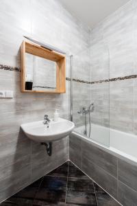La salle de bains est pourvue d'un lavabo et d'une baignoire. dans l'établissement Apartments Praha 6, à Prague