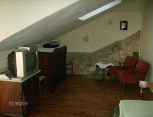 a living room with a tv and an attic at Apartments Senko in Trpanj