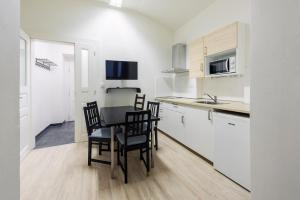 - une cuisine avec une table et des chaises dans la chambre dans l'établissement Apartments Praha 6, à Prague