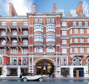 an old car parked in front of a building at St. James' Court, A Taj Hotel, London in London
