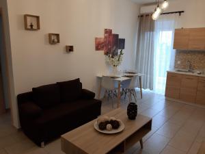 a living room with a black couch and a table at Skala Pearls A1 in Skala Kefalonias
