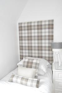 a bed with a plaid headboard and white pillows at Edinburgh37 in Edinburgh