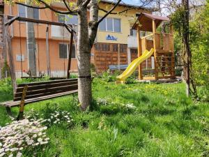 een park met een bank en een speeltuin bij Pamir Guest House in Shipkovo