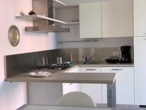 una cucina con armadi bianchi e piano di lavoro di Residence Oasi a Manerba del Garda