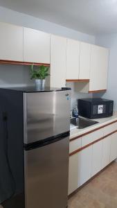 a kitchen with a stainless steel refrigerator and white cabinets at Executive Suites in Chapleau +27 photos