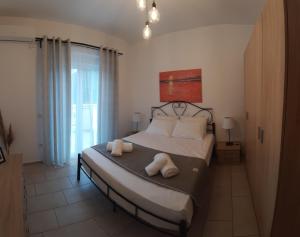 斯卡拉克弗隆尼亞斯的住宿－Skala Pearls A2，一间卧室配有一张床,上面有两条毛巾