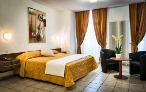 a hotel room with a bed and a table and chairs at Hotel dell'Angelo in Locarno