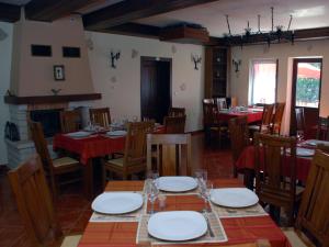 シギショアラにあるPensiunea Stejarulの木製テーブルと椅子(赤いテーブルクロス付)のあるレストラン