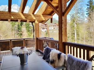 two dogs on a porch with a table and chairs at CHALET BELLE KAISER by Belle Stay in Going