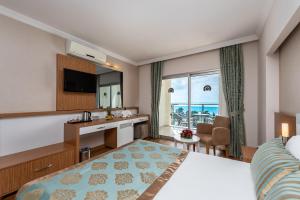 a hotel room with a bedroom with a bed and a desk at Annabella Diamond Hotel - All Inclusive in Avsallar