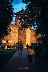 a group of people walking in front of a castle at OKKER Apartman in Gyula