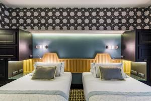 two beds in a hotel room with two at Room Mate Collection Alba, Madrid in Madrid