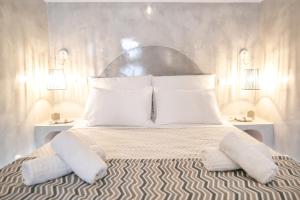 a bedroom with a large bed with white pillows at Thetis Cave Houses in Oia
