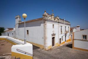 ein großes weißes Gebäude mit Straßenbeleuchtung davor in der Unterkunft Apartamento 2 - Fundação de Veiros in Veiros