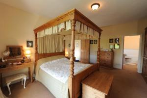 a bedroom with a canopy bed and a desk at Ford Down Farm B&B in South Molton