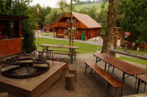 eine Gruppe von Picknicktischen und Bänken in einem Park in der Unterkunft Villa Donkey Chalet in Degersheim