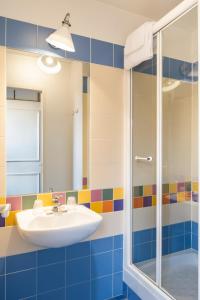 a bathroom with a sink, shower, and tub at Aparthotel Adagio Marne La Vallée - Val d'Europe in Serris