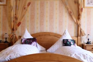 1 dormitorio con 1 cama con almohadas blancas en Hotel Restaurant Bürgerstube en Ulmen