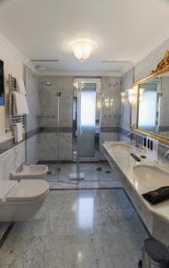 a bathroom with two sinks and a toilet and a shower at Ca' Bonfadini Historic Experience in Venice