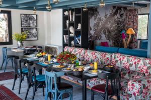 a dining room with tables and chairs and a couch at La Maison des Cèdres in Al Arz