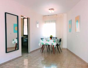 a dining room with a table with chairs and a mirror at 1Bdrm APT With Panoramic View of Sea and Mountains in Tiberias