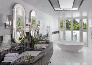 a bathroom with a large tub and a large mirror at Mandarin Oriental Hyde Park, London in London