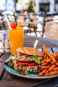 a sandwich and french fries on a plate with a drink at Hotel Restaurant Bürgerstube in Ulmen