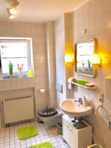 a bathroom with a sink and a toilet and two mirrors at Ferienwohnung in Binger Stadtmitte mit Balkon in Bingen am Rhein
