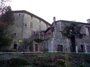 um edifício antigo com uma varanda e uma palmeira em Gîte B.Lay em Saint-Sèbastien