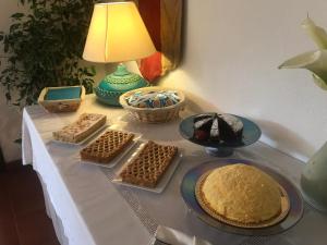 a table with a cake and other desserts on it at Hotel Spartivento in Chia