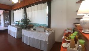 two tables with white table cloths in a room at Hotel Spartivento in Chia